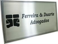 Placa de sinalização de escritório de advocacia, com logotipo e nome gravados em baixo relevo.